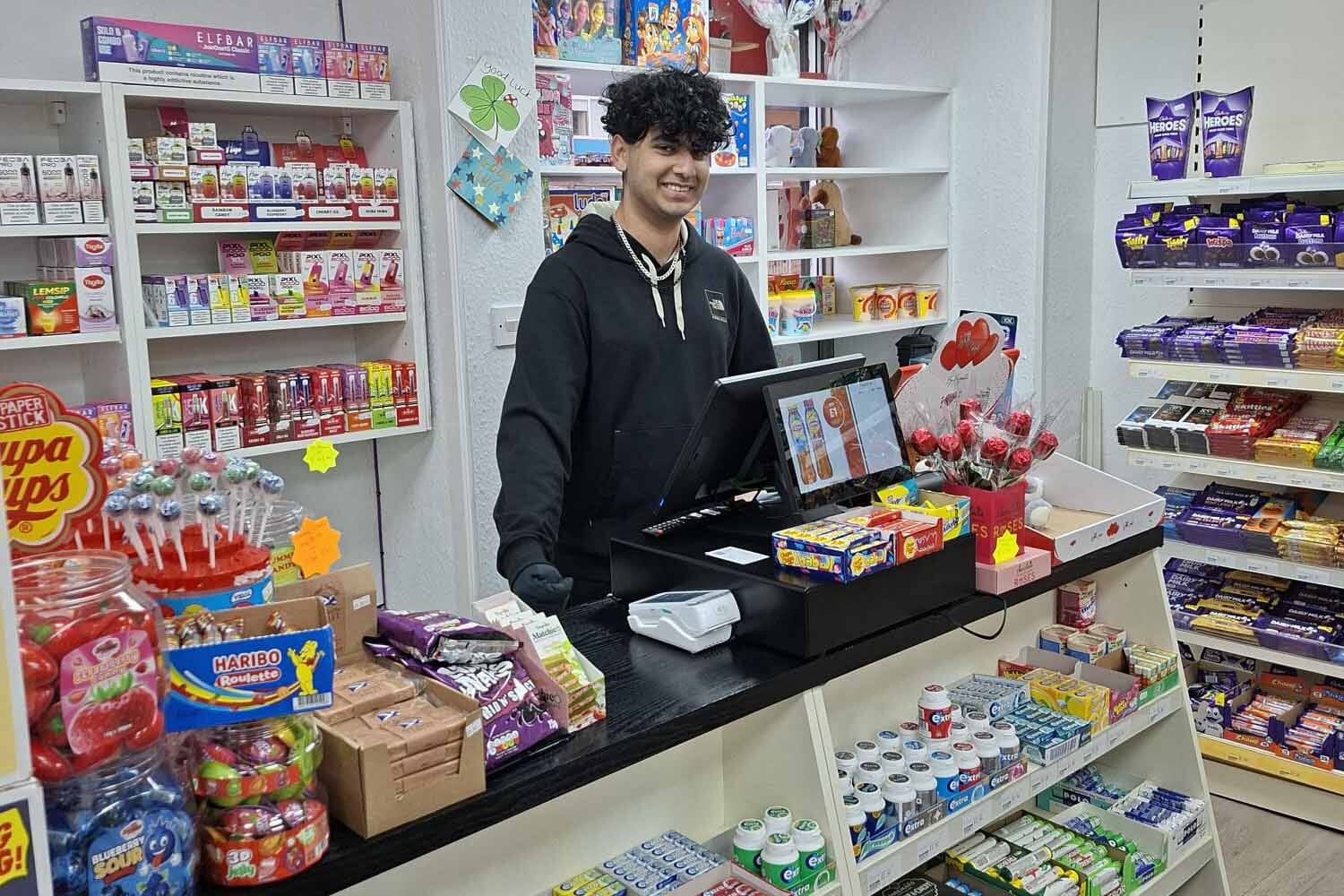 Deano shown behind the counter with the ShopMate till